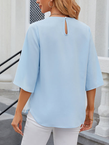Sky Blue - Women's light blue relaxed fit blouse featuring a pleated front neckline and short split sleeves, styled with white trousers.