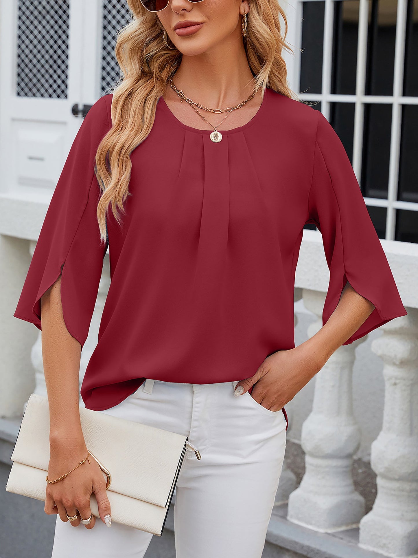 Burgundy - Women's light blue relaxed fit blouse featuring a pleated front neckline and short split sleeves, styled with white trousers.