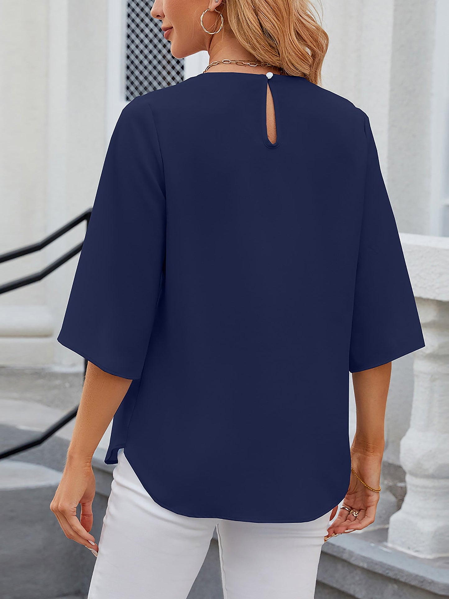 Navy Blue - Women's light blue relaxed fit blouse featuring a pleated front neckline and short split sleeves, styled with white trousers.