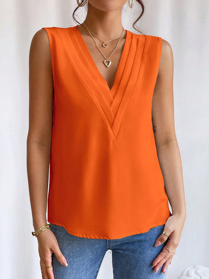 Orange - Women's solid white sleeveless blouse featuring a deep V-neckline with layered pleat detailing, styled with blue jeans and a black belt.