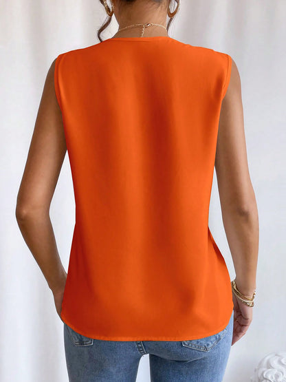 Orange - Women's solid white sleeveless blouse featuring a deep V-neckline with layered pleat detailing, styled with blue jeans and a black belt.