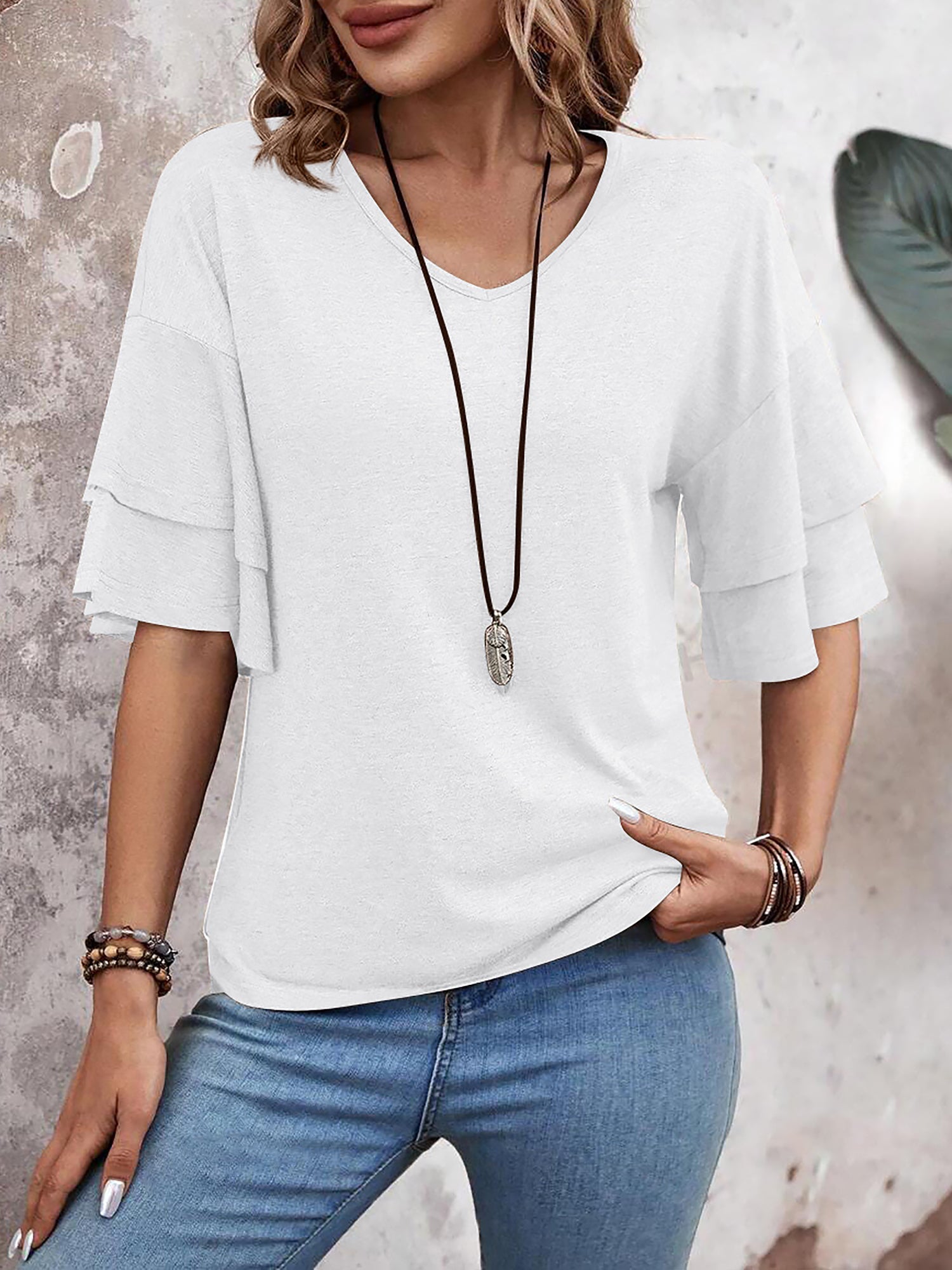 White - Women's solid pink V-neck blouse featuring tiered ruffle short sleeves, styled with blue jeans and a long pendant necklace.