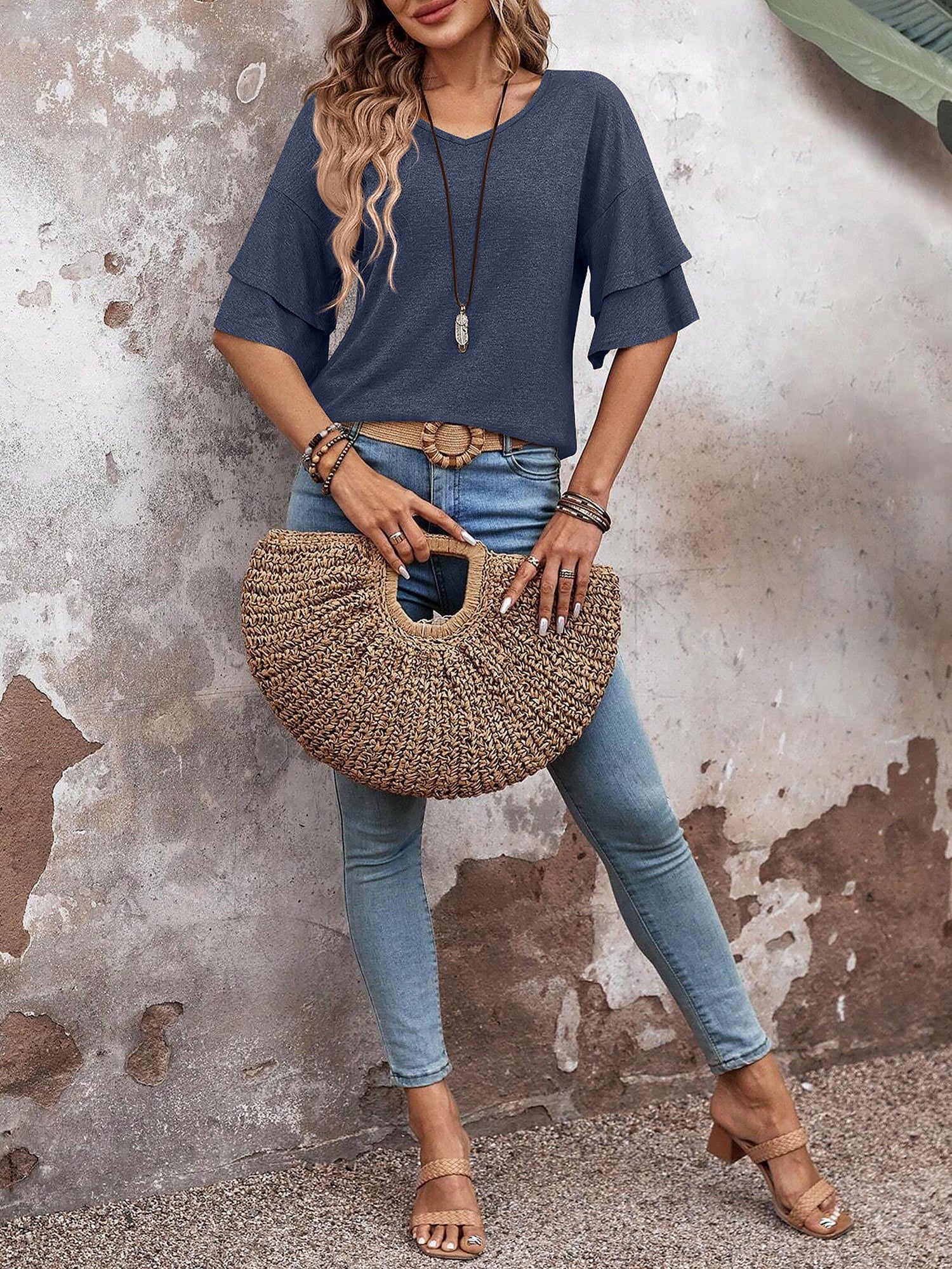 Navy Blue - Women's solid pink V-neck blouse featuring tiered ruffle short sleeves, styled with blue jeans and a long pendant necklace.