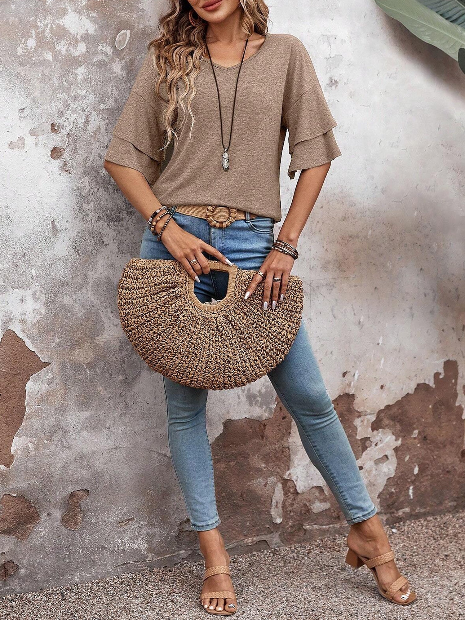 Camel - Women's solid pink V-neck blouse featuring tiered ruffle short sleeves, styled with blue jeans and a long pendant necklace.