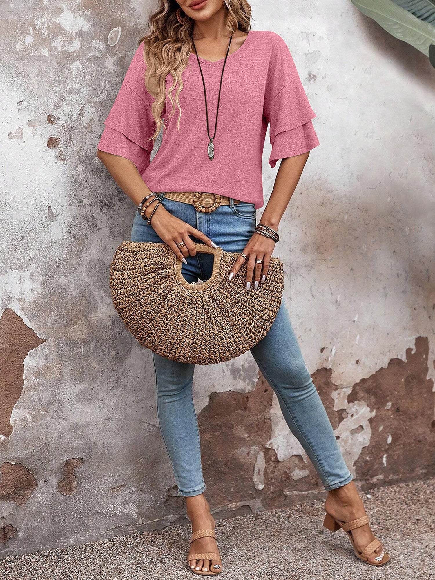Pink - Women's solid pink V-neck blouse featuring tiered ruffle short sleeves, styled with blue jeans and a long pendant necklace.