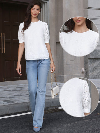 White - A woman models a light blue, short-sleeve eyelet blouse with a round neckline, paired with white wide-leg trousers.