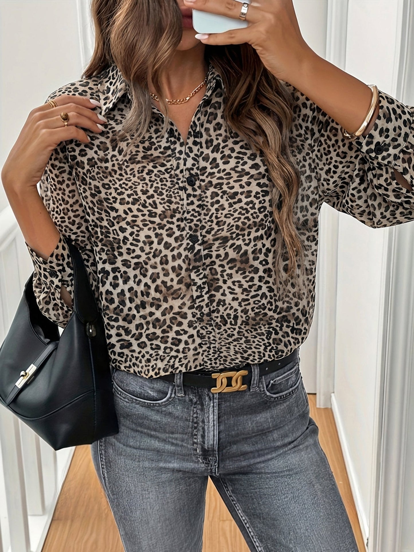 Brown - A woman wearing a long-sleeve leopard print button-down blouse, tucked into high-waisted grey jeans, accessorized with a gold necklace and black shoulder bag.