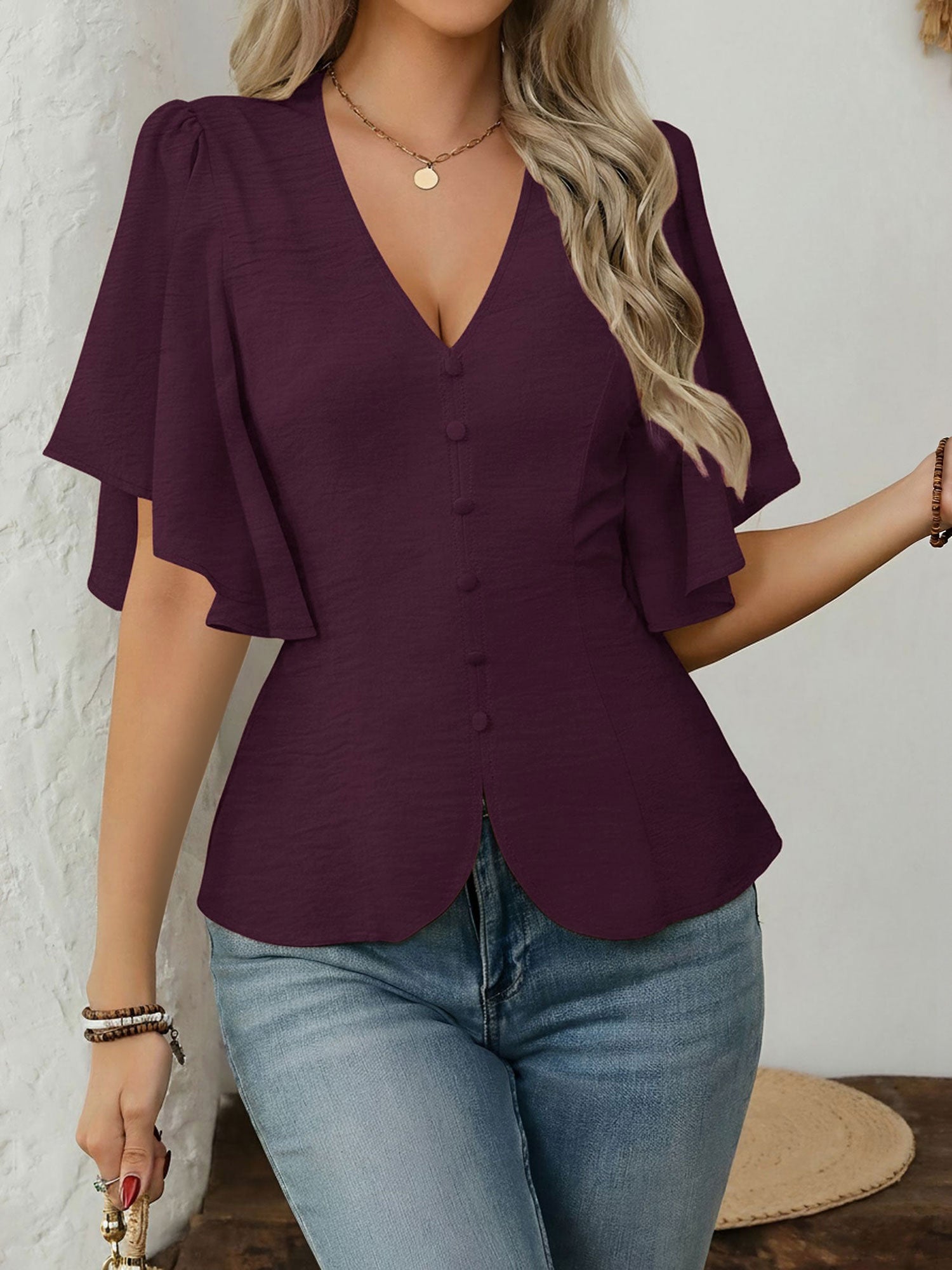 Dark Red - Women's rust orange short flutter sleeve blouse featuring a V-neckline, fabric-covered button front, and a tailored peplum waist, styled with blue jeans.