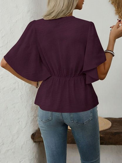 Dark Red - Women's rust orange short flutter sleeve blouse featuring a V-neckline, fabric-covered button front, and a tailored peplum waist, styled with blue jeans.