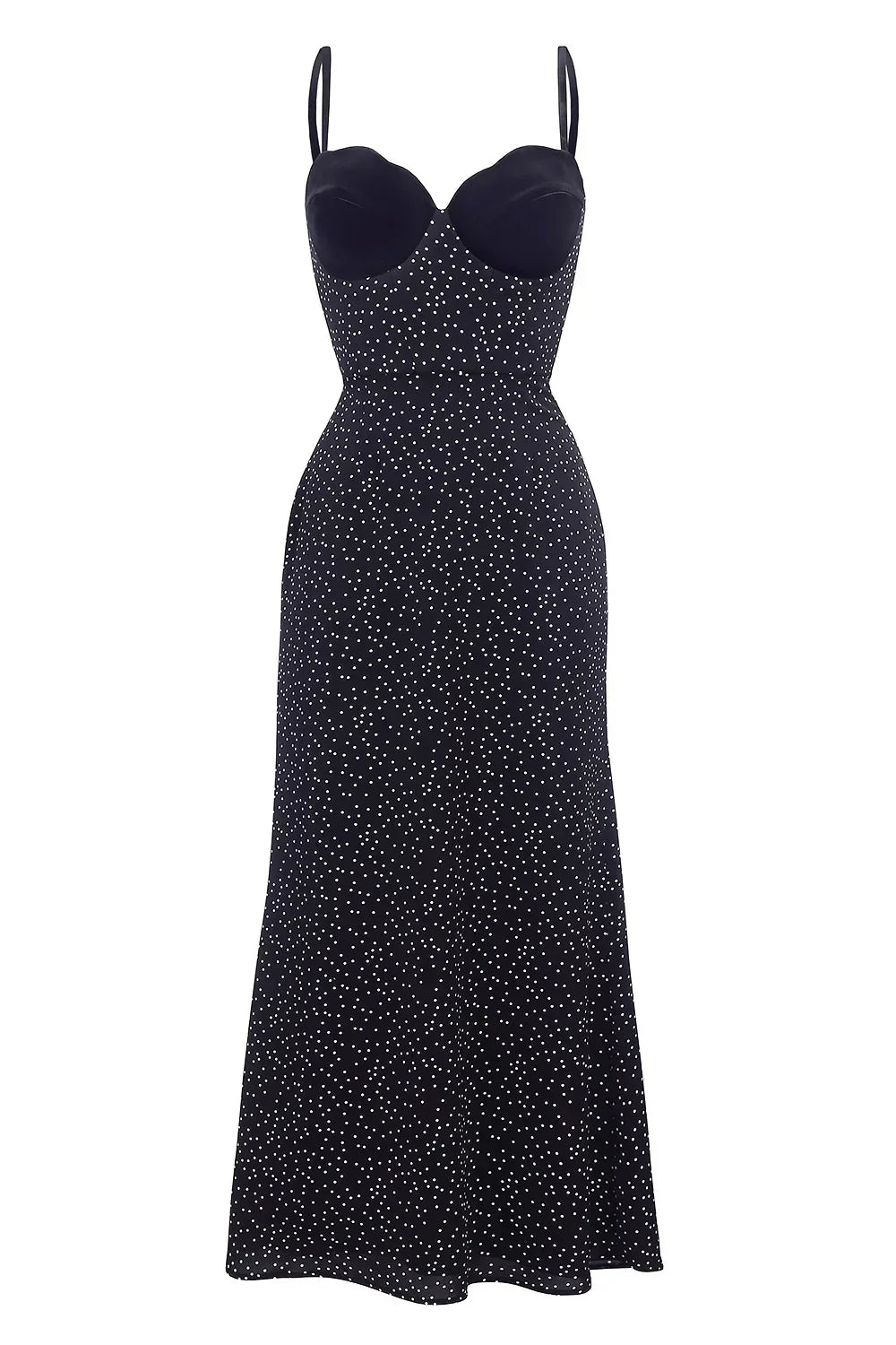 Black - Woman wearing an ankle-length polka dot dress featuring a velvet sweetheart bodice and delicate spaghetti straps, leaning against a white wall in a brightly lit minimalist room.