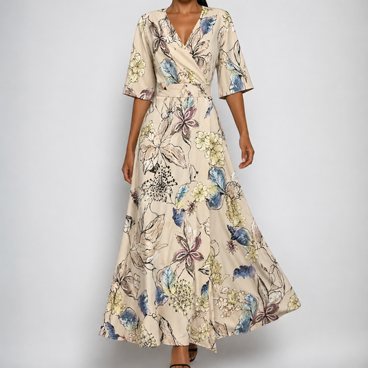 Beige - A woman wearing a cream-colored maxi dress featuring a watercolor floral print in blue, purple, and yellow, designed with a surplice V-neck, wide elbow-length sleeves, and a flowing skirt.