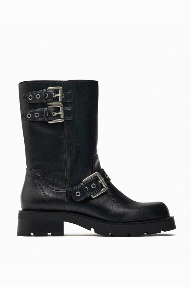 Black - A pair of women's dark brown faux leather mid-calf moto boots featuring three adjustable buckle straps and a chunky black lug sole.
