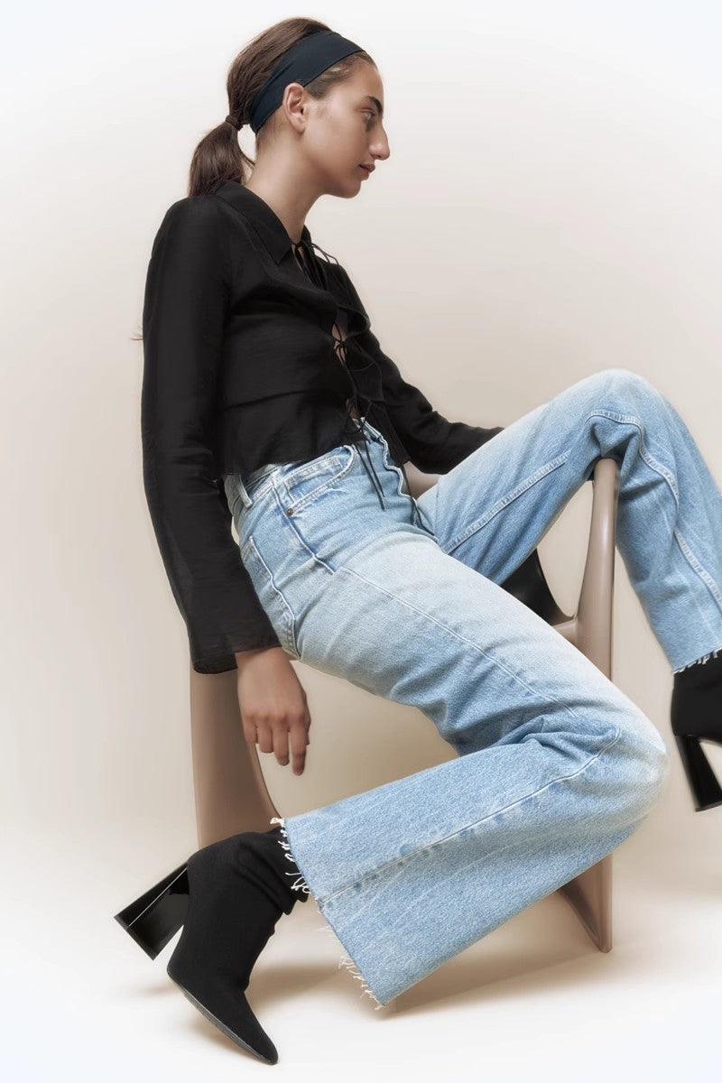 Women's black ribbed knit ankle sock boots featuring a pointed toe and a shiny block heel.