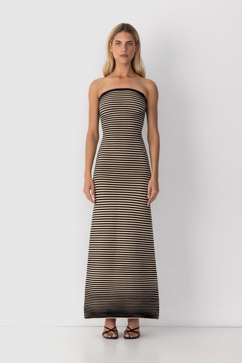 Black - A woman modeling a strapless knit maxi dress featuring a fitted column silhouette and an all-over horizontal stripe pattern.