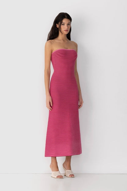 Hot Pink - A woman modeling a strapless knit maxi dress featuring a fitted column silhouette and an all-over horizontal stripe pattern.
