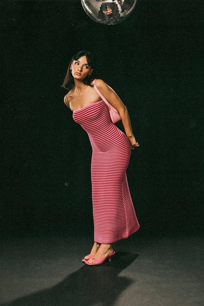 Hot Pink - A woman modeling a strapless knit maxi dress featuring a fitted column silhouette and an all-over horizontal stripe pattern.