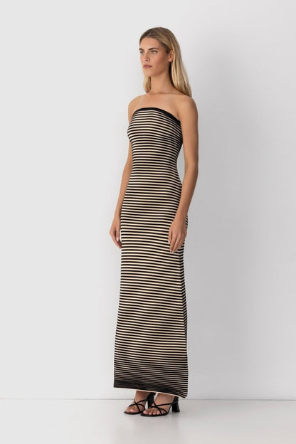 Black - A woman modeling a strapless knit maxi dress featuring a fitted column silhouette and an all-over horizontal stripe pattern.