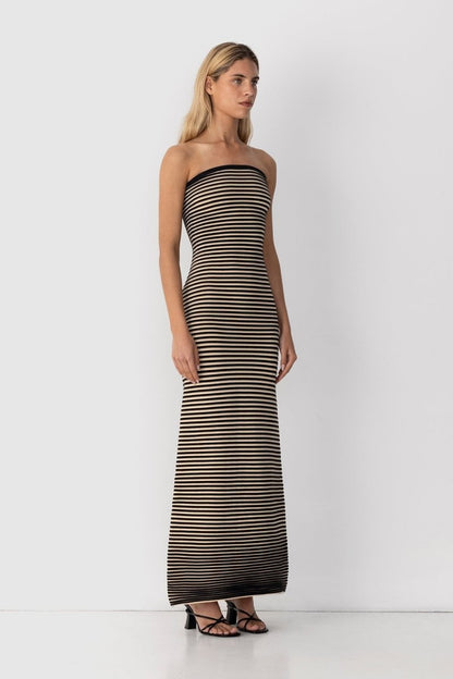 Black - A woman modeling a strapless knit maxi dress featuring a fitted column silhouette and an all-over horizontal stripe pattern.