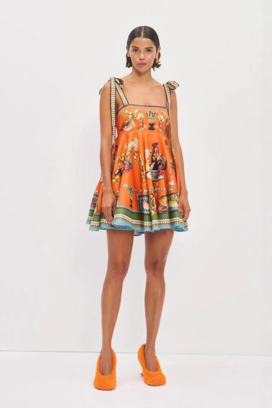 Orange color - Women's vibrant orange mini dress featuring an ornate still-life motif print, square neckline, thick tie-shoulder straps, and a flared A-line skirt with a contrasting green and blue border hem.