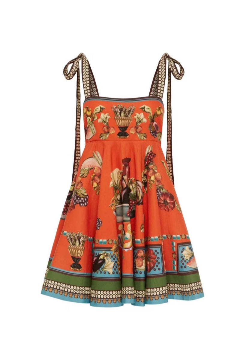 Orange color - Women's vibrant orange mini dress featuring an ornate still-life motif print, square neckline, thick tie-shoulder straps, and a flared A-line skirt with a contrasting green and blue border hem.