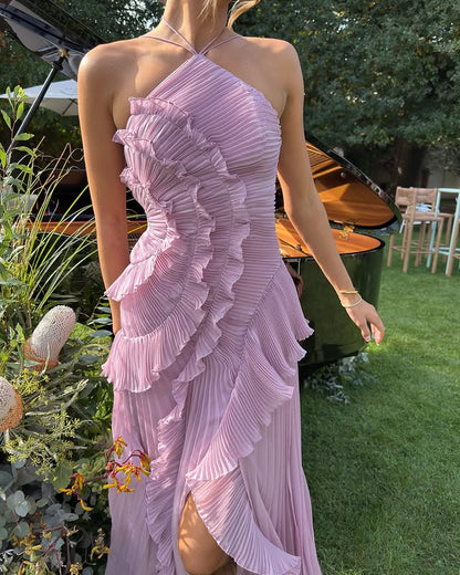 White - A woman wearing an elegant light purple midi dress featuring a halter neckline, all-over micro-pleating, and a dramatic asymmetrical cascading ruffle detail down the front.