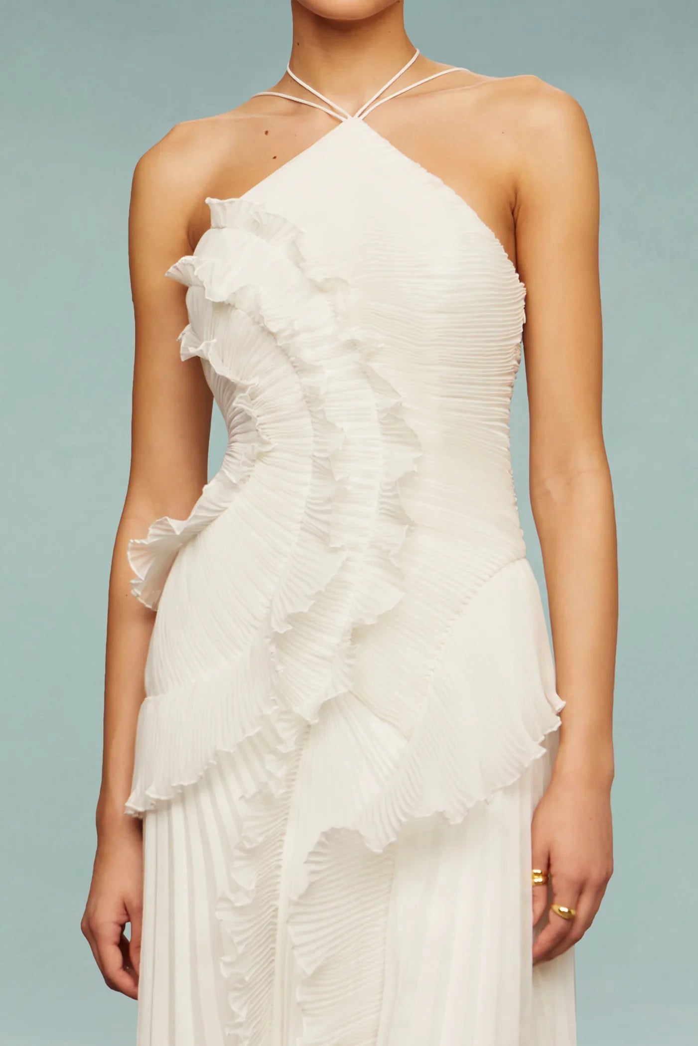 White - A woman wearing an elegant light purple midi dress featuring a halter neckline, all-over micro-pleating, and a dramatic asymmetrical cascading ruffle detail down the front.