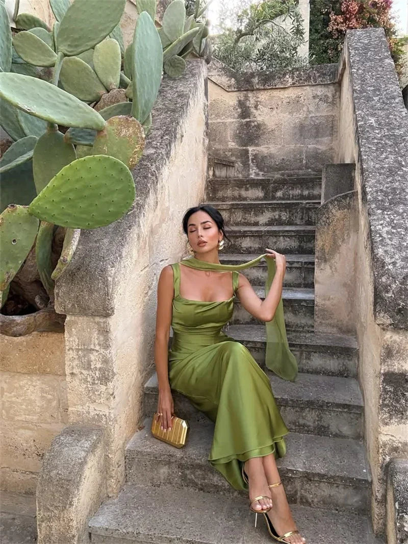 White - Women's elegant olive green satin slip dress featuring a cowl neckline, ruched bodice, wide straps, and a matching neck scarf detail, styled for a formal event.