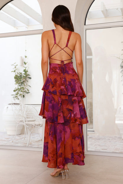 Yellow - A woman wearing a vibrant teal and blue abstract floral print maxi dress featuring a deep V-neckline and a dramatic tiered ruffle skirt.