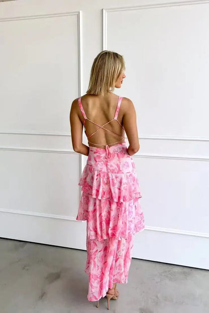 Yellow - A woman wearing a vibrant teal and blue abstract floral print maxi dress featuring a deep V-neckline and a dramatic tiered ruffle skirt.