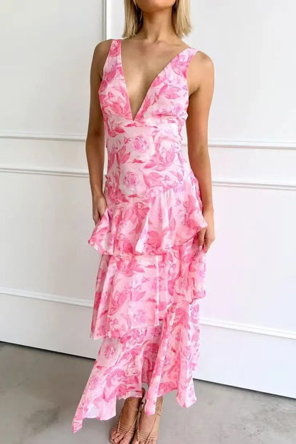 Pink - A woman wearing a vibrant teal and blue abstract floral print maxi dress featuring a deep V-neckline and a dramatic tiered ruffle skirt.