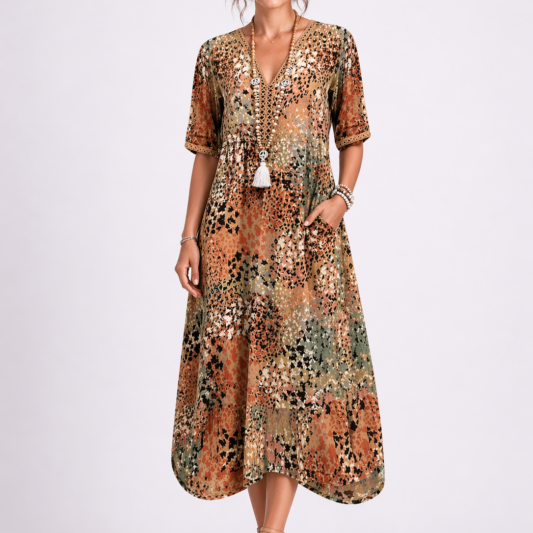 Sand & Beige - Woman wearing a relaxed fit abstract print midi dress with short sleeves, a V-neckline, and side pockets against a plain background.