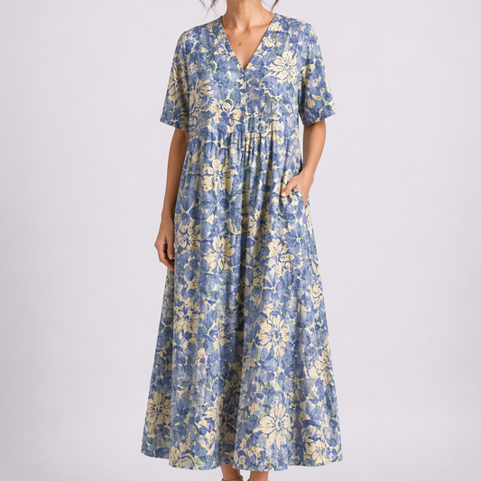 Blue - Model wearing a woven floral V-neck midaxi dress with short sleeves and side pockets against a plain grey background.