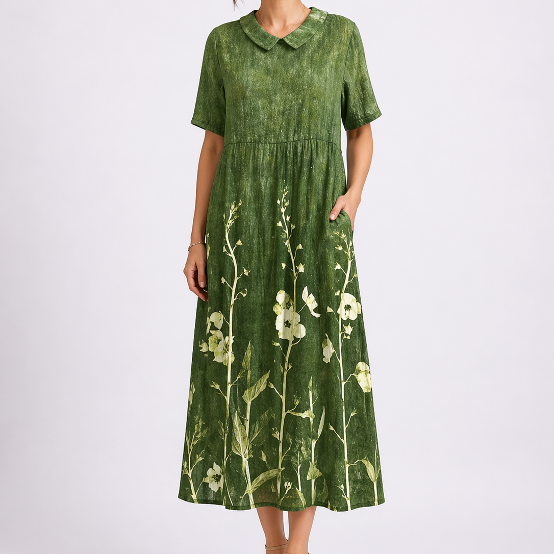 Green - Model wearing a woven floral V-neck midaxi dress with short sleeves and side pockets against a plain grey background.