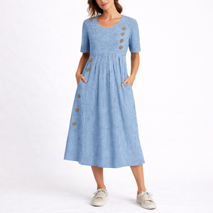 Blue - Model wearing a striped short-sleeve midi dress with asymmetric button detailing and side pockets against a plain background