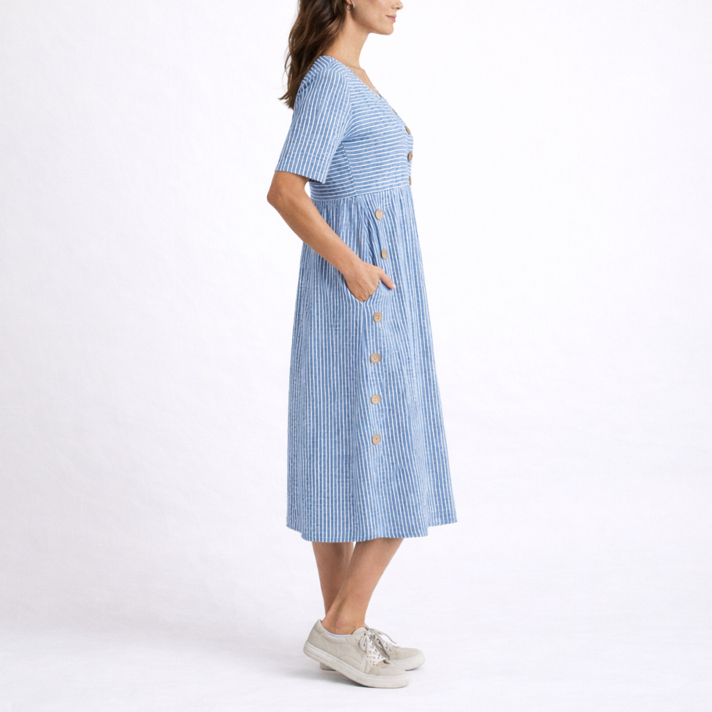 Blue - Model wearing a striped short-sleeve midi dress with asymmetric button detailing and side pockets against a plain background